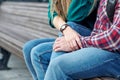 Lovely portrait of a young couple. They are sitting on the bench, embracing and kissing Royalty Free Stock Photo