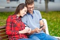 Lovely portrait of a young couple. They are sitting on the bench, embracing and kissing. Royalty Free Stock Photo