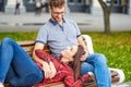 Lovely portrait of a young couple. They are sitting on the bench, embracing and kissing. Royalty Free Stock Photo