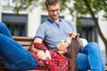 Lovely portrait of a young couple. They are sitting on the bench, embracing and kissing. Royalty Free Stock Photo