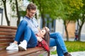 Lovely portrait of a young couple. They are sitting on the bench, embracing and kissing. Royalty Free Stock Photo