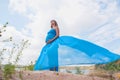 Lovely pregnant girl against a background of water and sky in a cloth. Royalty Free Stock Photo