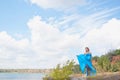 Lovely pregnant girl against a background of water and sky in a cloth. Royalty Free Stock Photo