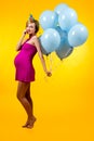 Lovely pregnant young woman with blue balloons