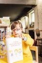 Lovely preschool girl with genetic disorder looking at kids book Royalty Free Stock Photo