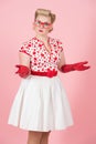 Lovely puzzled caucasian female with surprised expression with hands and glassed poses against pastel pink studio background