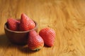 Lovely red fresh ripe strawberry in wood bowl on wooden table, copy space Royalty Free Stock Photo