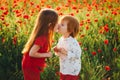 Lovely red-haired children in a field of red poppies. Royalty Free Stock Photo