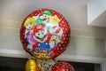 Lovely scene with large helium-filled balloons featuring favorite cartoon characters inside cozy apartment,