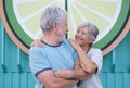 Lovely senior couple hugging and looking each other standing in city street at sunset light Royalty Free Stock Photo