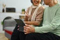 Lovely senior couple using digital tablet for watching video or shopping online at home. Elderly and technology concept Royalty Free Stock Photo