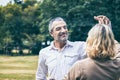 Lovely senior elderly smiling couple man and woman dancing in the park in romantic moment. Warm heart marriage and lover bonding a Royalty Free Stock Photo