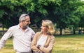 Lovely senior elderly smiling couple man and woman look at each other in romantic moment in the park. Warm heart marriage and love Royalty Free Stock Photo