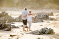 Lovely senior mature couple on their 60s or 70s retired walking happy and relaxed on beach sea shore in romantic aging together an Royalty Free Stock Photo