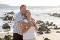 Lovely senior mature couple on their 60s or 70s retired walking happy and relaxed on beach sea shore in romantic aging together Royalty Free Stock Photo