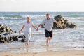 Lovely senior mature couple on their 60s or 70s retired walking happy and relaxed on beach sea shore in romantic aging together