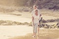 Lovely senior mature couple on their 60s or 70s retired walking happy and relaxed on beach sea shore in romantic aging together Royalty Free Stock Photo