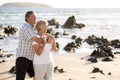 Lovely senior mature couple on their 60s or 70s retired walking happy and relaxed on beach sea shore in romantic aging together Royalty Free Stock Photo