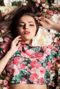 Lovely sensual woman lying on flowers