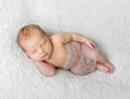 Lovely sleeping baby covered with light knitted shawl