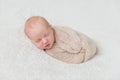 Lovely sleeping baby wrapped in beige diaper