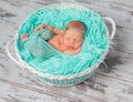 Lovely sleeping newborn girl in round cot with turquoise blanket Royalty Free Stock Photo