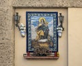 Lovely small altar with a painting of Madonna on mosaic tiles in a wall niche in Seville, Andalusia, Spain.