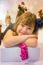 pretty little girl in a dress waiting at the foot of the Christmas tree for the opening of presents Royalty Free Stock Photo