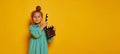 Lovely smiling little girl holding director's film movie slateboard over yellow studio background. Concept of human Royalty Free Stock Photo