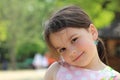 Lovely smiling little girl with a tail in a sundress on the shore of a pond Royalty Free Stock Photo