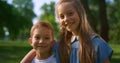 Lovely smiling siblings hugging in park. Preteen kids posing in park close up.