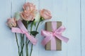 Lovely soft orange pink color rose tied by pink ribbon and brown gift box on white wood table background, sweet valentine present