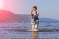 Lovely sporty mature woman stands and splashes water on the beach on the Volga river on a summer sunny day against the background Royalty Free Stock Photo