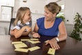 Lovely sweet and happy 6 years old daughter learning reading with flash card words game at home kitchen playing with her young bea Royalty Free Stock Photo