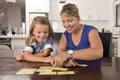 Lovely sweet and happy 6 years old daughter learning reading with flash card words game at home kitchen playing with her young bea Royalty Free Stock Photo