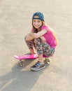 Girl with long hair sitting on skating board Royalty Free Stock Photo