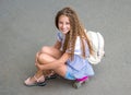 Girl with long hair sitting on skating board Royalty Free Stock Photo