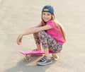 Girl with long hair sitting on skating board Royalty Free Stock Photo