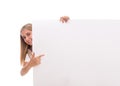 Lovely teen girl is popping out from the side of white blank banner,isolated Royalty Free Stock Photo