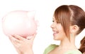 Lovely teenage girl with piggy bank