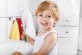 Lovely toddler with blue eyes and blond hair brushing his teeth Royalty Free Stock Photo