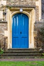 Blue large wooden church door with stone archway & lantern on top Royalty Free Stock Photo