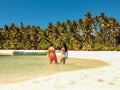 Lovely travel couple standing near palm trees in paradise Onok Island in Balabac Palawan in Philippines Royalty Free Stock Photo