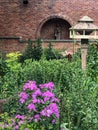 Statute by brick wall in garden setting