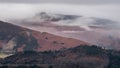 Lovely Winter sunrise landscape image of view from Walla Crag in Lake District towards distant mountains with low cloud