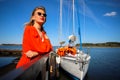 Lovely woman in a bright red suit on the background of the yacht. The blonde in sunglasses on the background of the Royalty Free Stock Photo