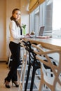 Lovely woman in business suit standing near table with laptop Royalty Free Stock Photo