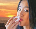 Lovely woman fights the heat by placing an ice cube to her lips