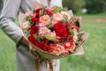 Lovely woman holding a beautiful autumn bouquet. flower arrangement with carnations and red garden roses. Color pink Royalty Free Stock Photo