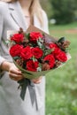 Lovely woman holding a beautiful autumn bouquet. flower arrangement with carnations and red garden roses. Color pink Royalty Free Stock Photo